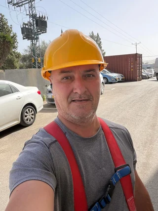 איש עבודה עם קסדה ורתמה באתר עבודה