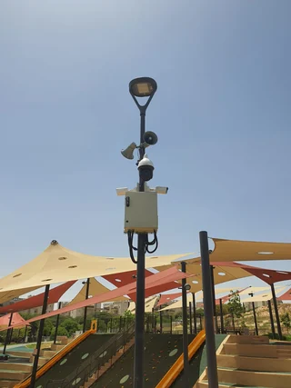 עמוד עם מצלמות אבטחה וארון ציוד במתחם חוץ