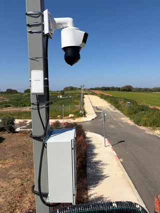 מצלמת PTZ וארון ציוד המותקנים על עמוד לצד דרך